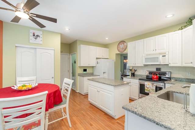 4049 Sherbourne Dr, Independence, KY 41051 - kitchen with white appliances, light wood finished floors, light stone countertops, a kitchen island, and white cabinetry