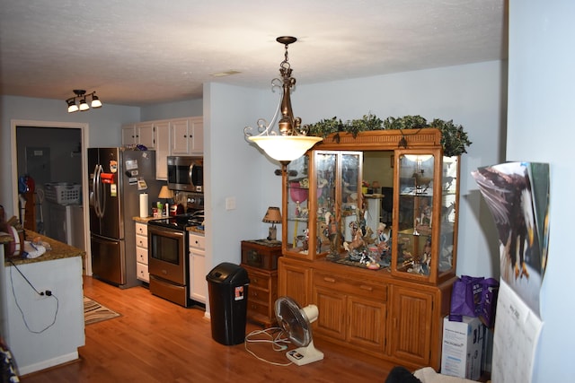 185 Cave Run Dr Unit 5, Erlanger, KY 41018 - kitchen featuring appliances with stainless steel finishes, light wood-type flooring, white cabinets, and decorative light fixtures