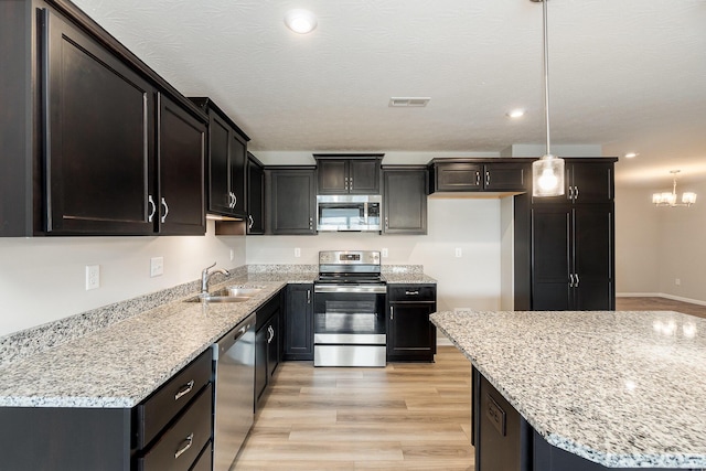 2535 Crosshill Dr, Crescent Springs, KY 41017 - kitchen featuring stainless steel appliances, a sink, light stone countertops, light wood finished floors, and recessed lighting