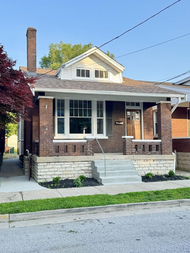 618 E 2nd St, Newport, KY 41071 - view of front of house with brick siding, covered porch, roof with shingles, and a chimney