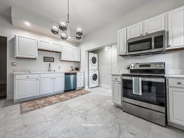 1816 Scott St, Covington, KY 41014 - kitchen featuring appliances with stainless steel finishes, stacked washer and clothes dryer, a chandelier, light countertops, and a sink