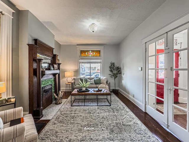1816 Scott St, Covington, KY 41014 - living room with a tiled fireplace, dark wood-style flooring, french doors, a textured ceiling, and baseboards