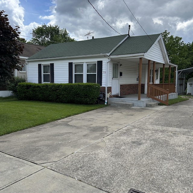 39 Sanders Dr, Florence, KY 41042 - view of front of home featuring a porch, a front yard, roof with shingles, and brick siding