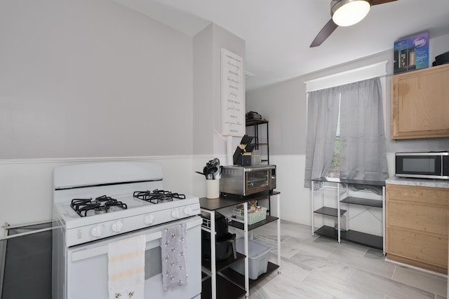 622 W 12th St, Covington, KY 41011 - kitchen featuring white gas range oven, stainless steel microwave, light brown cabinets, and ceiling fan