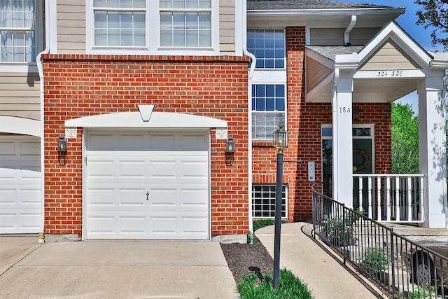 328 Deepwoods Dr, Highland Heights, KY 41076 - view of exterior entry with brick siding, concrete driveway, an attached garage, and a shingled roof