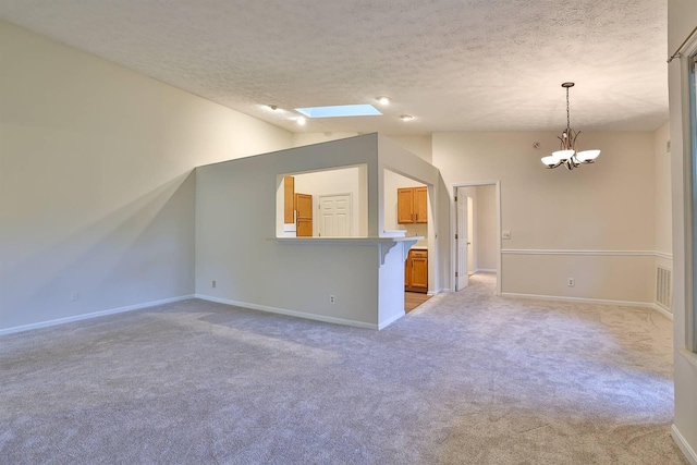 328 Deepwoods Dr, Highland Heights, KY 41076 - unfurnished living room with a chandelier, a textured ceiling, light carpet, a skylight, and baseboards