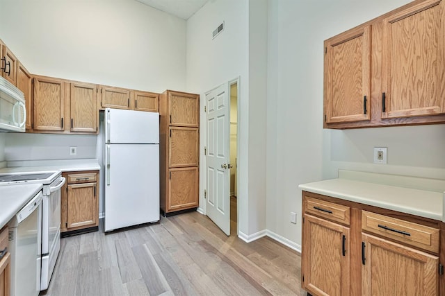328 Deepwoods Dr, Highland Heights, KY 41076 - kitchen featuring white appliances, light wood finished floors, a towering ceiling, light countertops, and baseboards