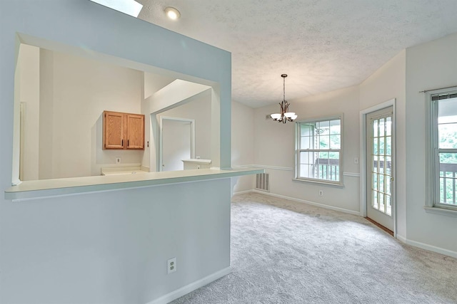 328 Deepwoods Dr, Highland Heights, KY 41076 - kitchen featuring baseboards, light colored carpet, brown cabinetry, a chandelier, and decorative light fixtures