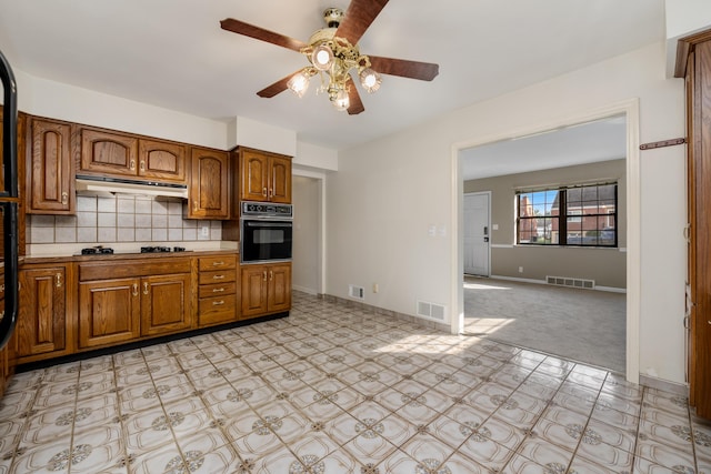 420 Locust St, Erlanger, KY 41018 - kitchen with black appliances, under cabinet range hood, ceiling fan, and brown cabinets