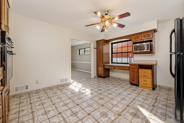 420 Locust St, Erlanger, KY 41018 - kitchen with stainless steel microwave, ceiling fan, brown cabinets, and light flooring