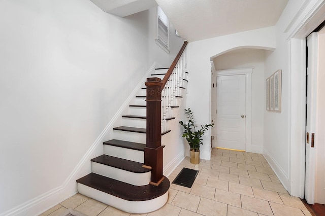 645 Maple Ave, Newport, KY 41071 - stairs with arched walkways, tile patterned flooring, and baseboards