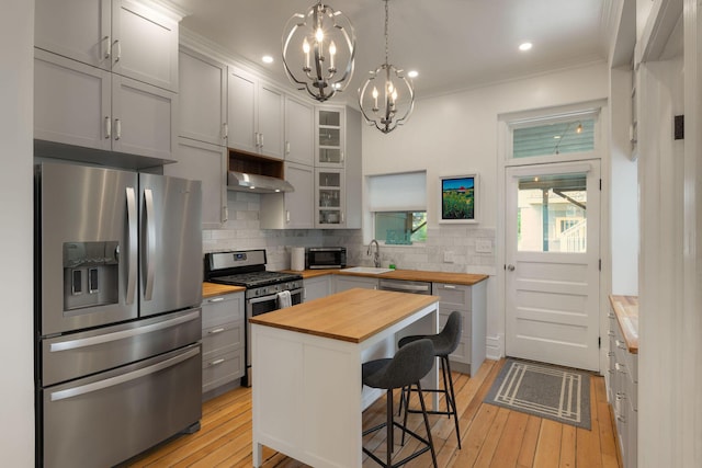 411 Elm St, Ludlow, KY 41016 - kitchen featuring stainless steel appliances, wooden counters, a chandelier, backsplash, and a kitchen bar