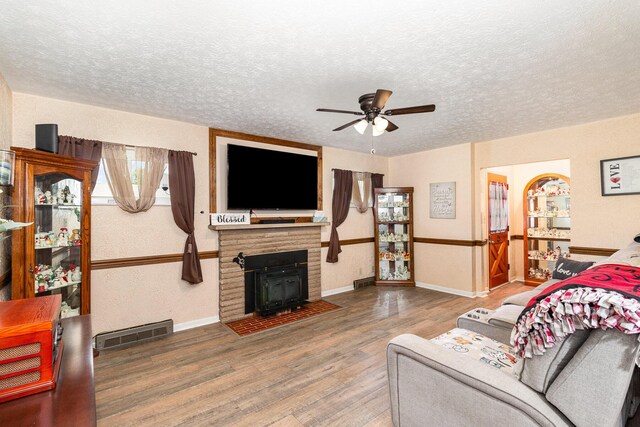304 Humes Ridge Rd, Williamstown, KY 41097 - living room featuring wood finished floors, a ceiling fan, a textured ceiling, a fireplace with flush hearth, and baseboards