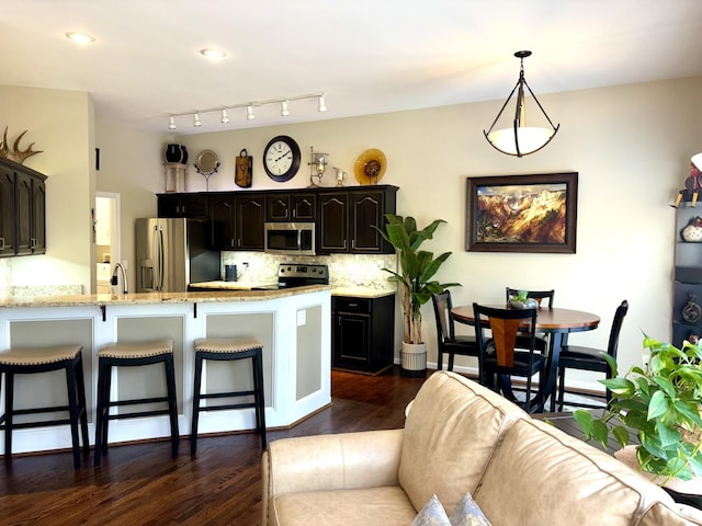 1940 Marktwain Way, Villa Hills, KY 41017 - kitchen with stainless steel appliances, a kitchen breakfast bar, a peninsula, dark wood-style flooring, and backsplash