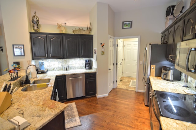 1940 Marktwain Way, Villa Hills, KY 41017 - kitchen with appliances with stainless steel finishes, a sink, light stone counters, decorative backsplash, and dark wood finished floors