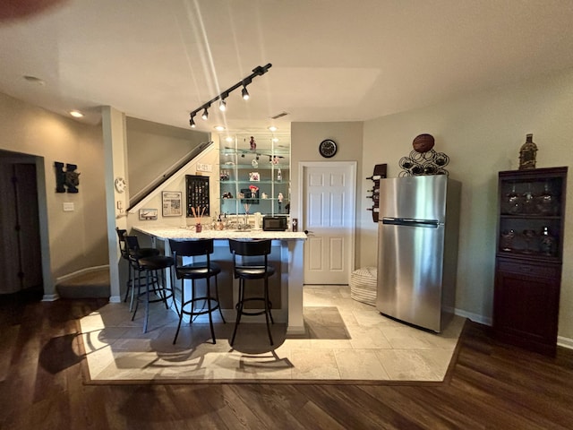 1940 Marktwain Way, Villa Hills, KY 41017 - kitchen featuring freestanding refrigerator, light wood-style flooring, a kitchen breakfast bar, track lighting, and a peninsula