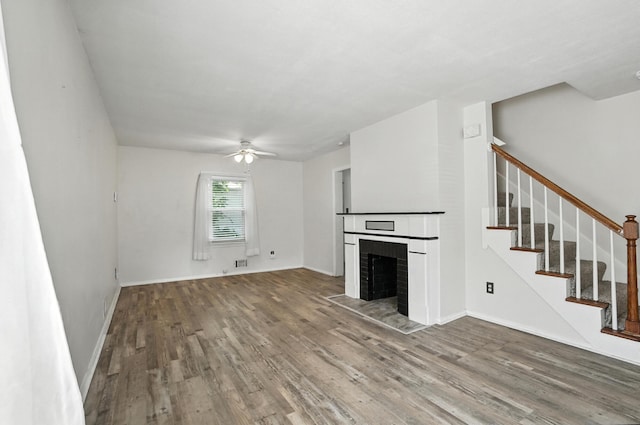 3314 Elizabeth St, Erlanger, KY 41018 - unfurnished living room featuring a brick fireplace, wood finished floors, ceiling fan, and stairway