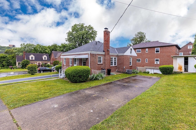1191 Wilson Rd, Bellevue, KY 41073 - view of front of home featuring brick siding, a chimney, a front lawn, and central air condition unit