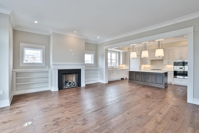 1 Highland Ave Unit 208, Fort Thomas, KY 41075 - unfurnished living room with crown molding, wood finished floors, a fireplace, recessed lighting, and a sink