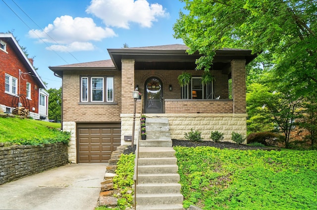 134 Strathmore Ave, Fort Thomas, KY 41075 - view of front of house featuring brick siding, driveway, covered porch, and a garage