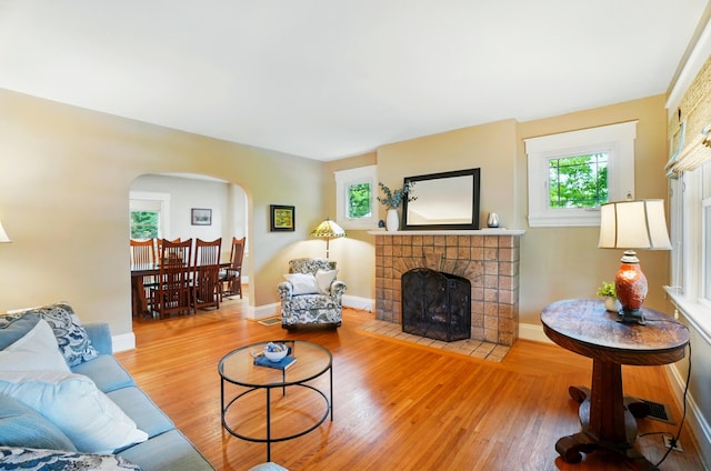 134 Strathmore Ave, Fort Thomas, KY 41075 - living area featuring a tiled fireplace, arched walkways, wood finished floors, and baseboards