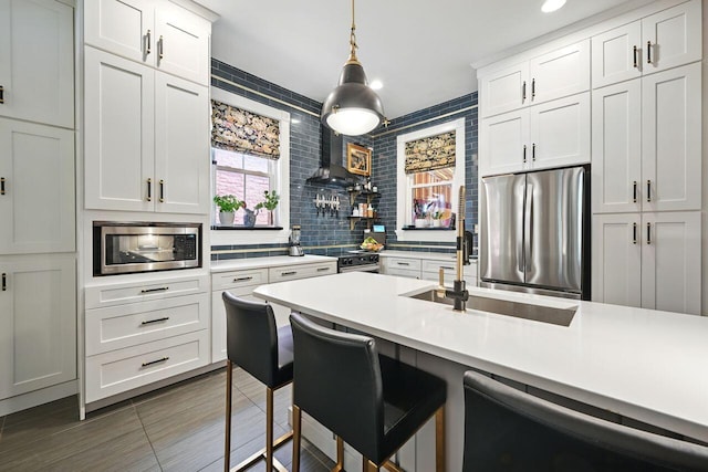 842 Monroe St, Newport, KY 41071 - kitchen with stainless steel appliances, light countertops, a kitchen bar, white cabinetry, and pendant lighting