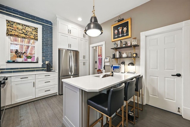 842 Monroe St, Newport, KY 41071 - kitchen with freestanding refrigerator, light countertops, white cabinetry, a breakfast bar, and pendant lighting