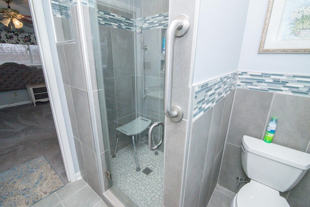 1727 Shaw Rd, Independence, KY 41051 - ensuite bathroom featuring tile walls, a stall shower, a wainscoted wall, toilet, and tile patterned floors