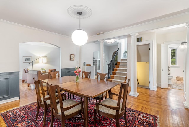 1058 Emerson Rd, Park Hills, KY 41011 - dining space featuring ornate columns, ornamental molding, a wainscoted wall, light wood-style floors, and stairway