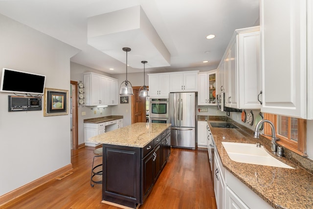 2090 Edenderry Dr, Fort Mitchell, KY 41017 - kitchen with stainless steel appliances, a sink, white cabinets, wood finished floors, and a kitchen island