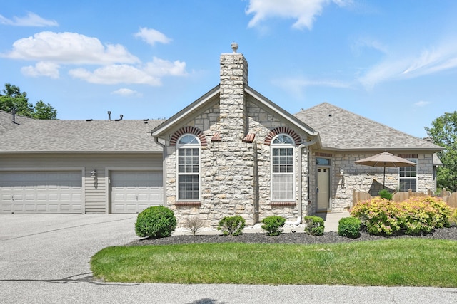 9072 Timberbrook Ln Unit B, Florence, KY 41042 - view of front of property with a garage, stone siding, a shingled roof, a chimney, and asphalt driveway