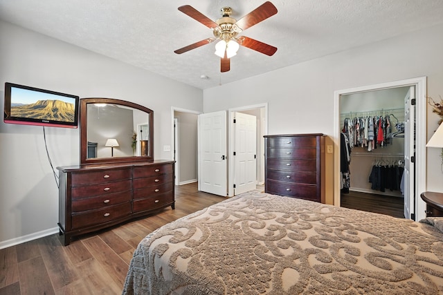 9072 Timberbrook Ln Unit B, Florence, KY 41042 - bedroom featuring wood finished floors, baseboards, a spacious closet, a textured ceiling, and a ceiling fan