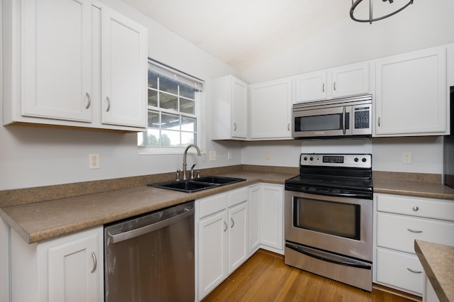 1837 Asbury Way, Hebron, KY 41048 - kitchen with stainless steel appliances, a sink, lofted ceiling, white cabinetry, and light wood-style floors