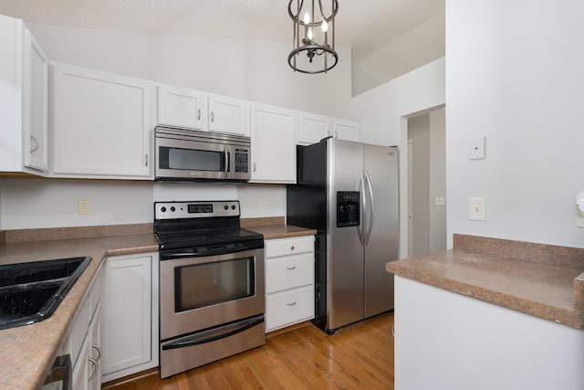 1837 Asbury Way, Hebron, KY 41048 - kitchen with appliances with stainless steel finishes, white cabinetry, vaulted ceiling, light wood-style floors, and a sink