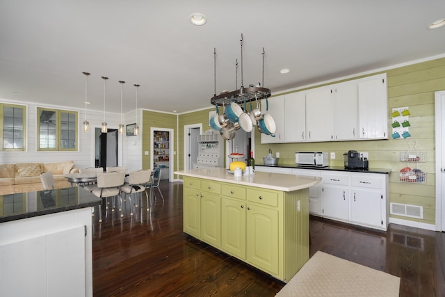 1120 Keefer Rd, Corinth, KY 41010 - kitchen with white microwave, dark wood-style flooring, wood walls, a kitchen island, and white cabinetry