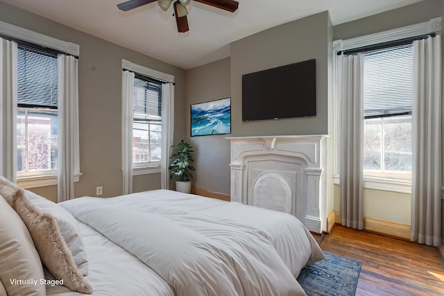 1707 Eastern Ave Unit 1709, Covington, KY 41014 - bedroom featuring baseboards, wood finished floors, a fireplace, and a ceiling fan