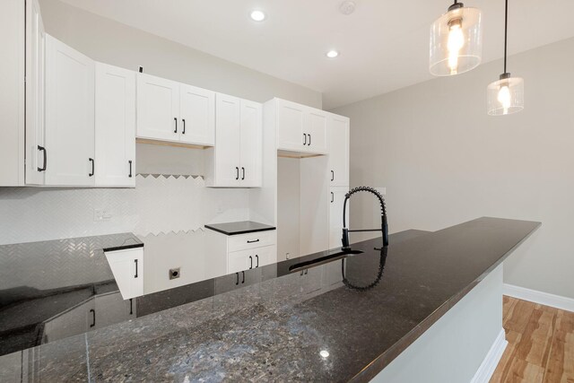 1026 Orchard St, Newport, KY 41071 - kitchen with a sink, dark stone countertops, light wood-style flooring, tasteful backsplash, and white cabinetry