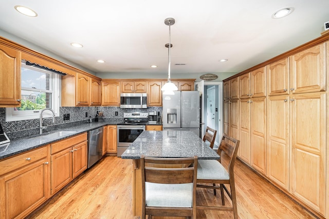 10659 Mountain Laurel Way, Union, KY 41091 - kitchen featuring stainless steel appliances, light wood-style flooring, backsplash, dark stone countertops, and a sink