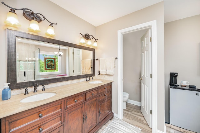 10659 Mountain Laurel Way, Union, KY 41091 - bathroom featuring toilet, double vanity, a chandelier, wood finished floors, and baseboards