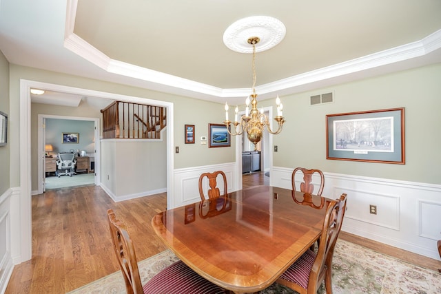 10659 Mountain Laurel Way, Union, KY 41091 - dining space featuring a tray ceiling, a chandelier, light wood-style floors, wainscoting, and ornamental molding