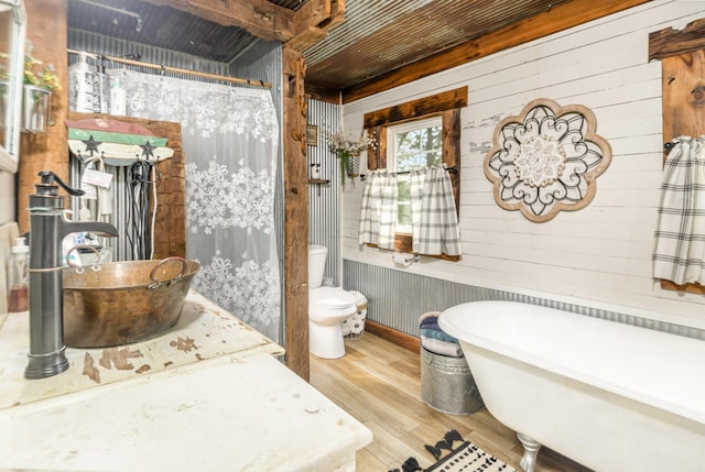 605 Lemon Northcutt Rd, Dry Ridge, KY 41035 - full bathroom with wood finished floors, a freestanding tub, toilet, wooden walls, and a shower with curtain
