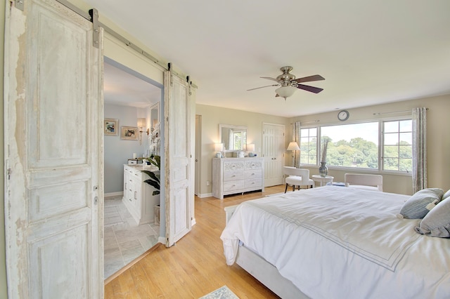 141 Manor Ln, Fort Thomas, KY 41075 - bedroom with a barn door, light wood-type flooring, and ceiling fan