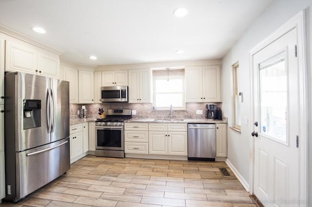 212 James Ave, Erlanger, KY 41018 - kitchen featuring appliances with stainless steel finishes, a sink, tasteful backsplash, light wood finished floors, and recessed lighting
