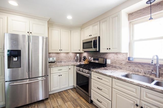 212 James Ave, Erlanger, KY 41018 - kitchen with stainless steel appliances, a sink, light wood-type flooring, tasteful backsplash, and light stone counters