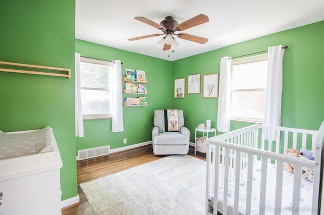 212 James Ave, Erlanger, KY 41018 - bedroom featuring a nursery area, wood finished floors, baseboards, and a ceiling fan