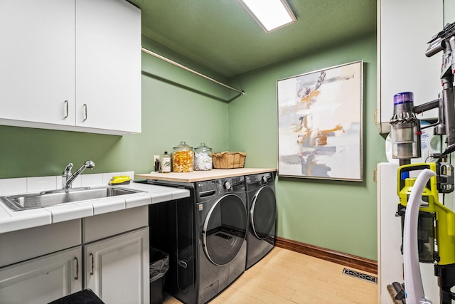 2709 Longbranch Rd, Union, KY 41091 - laundry area featuring cabinet space, separate washer and dryer, light wood-style flooring, and baseboards