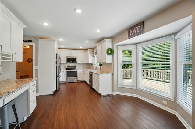 856 Moonstone Ct, Crescent Springs, KY 41017 - kitchen with appliances with stainless steel finishes, dark wood finished floors, a sink, light stone counters, and white cabinets