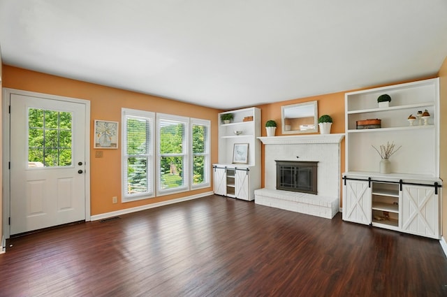856 Moonstone Ct, Crescent Springs, KY 41017 - unfurnished living room with dark wood finished floors, a brick fireplace, baseboards, and built in shelves
