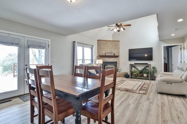 8949 E Main St, Alexandria, KY 41001 - dining area with light wood-style floors, a ceiling fan, a fireplace, vaulted ceiling, and french doors