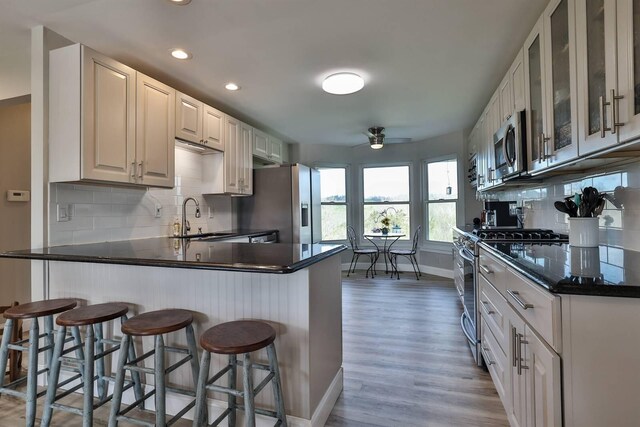 8949 E Main St, Alexandria, KY 41001 - kitchen featuring stainless steel appliances, ceiling fan, a sink, dark countertops, and backsplash